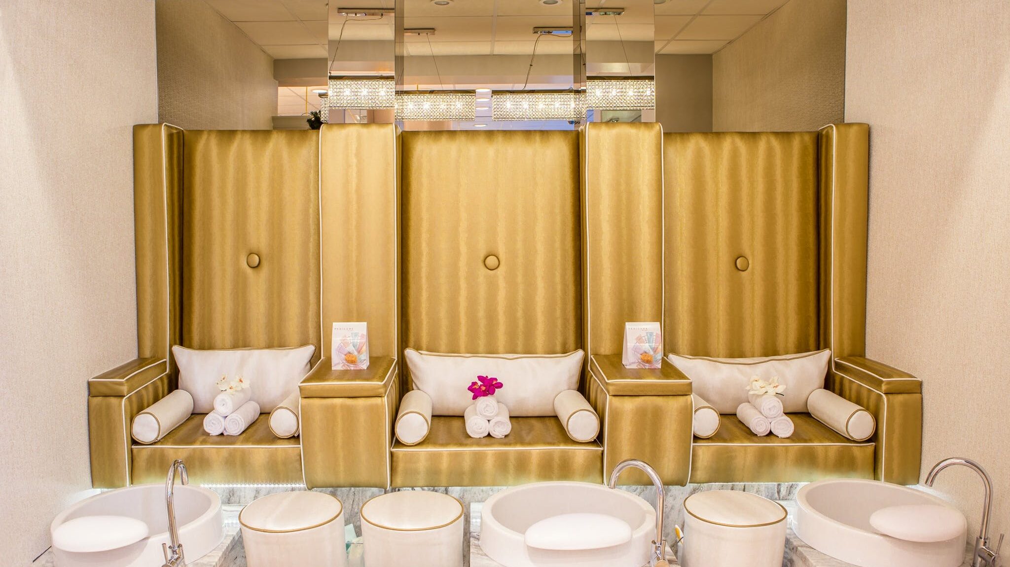 Luxury spa seating area with padded chairs and individual foot soak basins arranged in a calm indoor setting